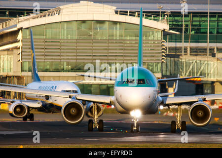 Aer Lingus Airbus A320 taxis onto runway 28 at Dublin airport, as a Ryanair Boeing 737-800 follows. Stock Photo