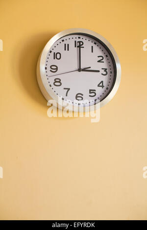 Clock on the wall showing the time of 3 O'Clock Stock Photo