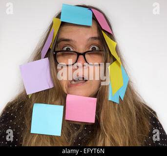 Woman with colorful post it notes stuck on her face and hair. Stock Photo