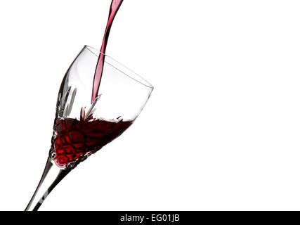 Red wine being poured into drinking glass on white background Stock Photo