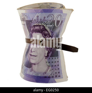 A roll of UK bank notes held with leather belt concept image of cutting back or tightening belt Stock Photo