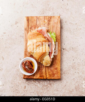 Ham croissant sandwich on stone textured background Stock Photo