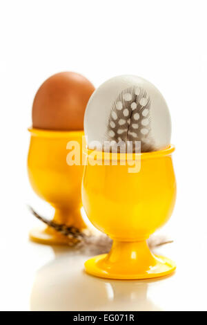 eggs  in yellow eggcups  isolated on white Stock Photo