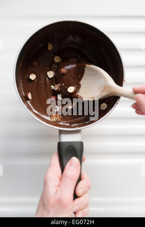 Baking with melted chocolate and nut sauce in a saucepan. Stock Photo