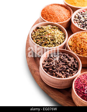 assorted spices in a wooden bowl close-up on white background Stock Photo