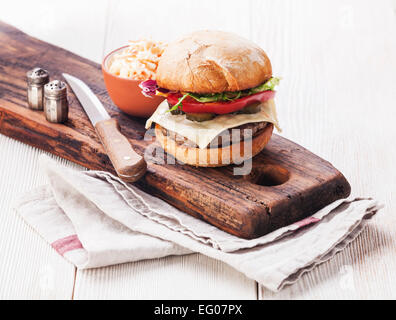Burger with coleslaw on white wooden background Stock Photo