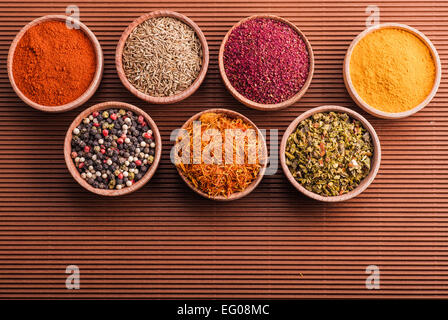 assorted spices in a wooden bowl on a brown background Stock Photo