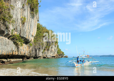 El Nido, Philippines - January 11,2015: Tropical beach in El Nido, Palawan, with a boat man on a tipical Philippinos boat Stock Photo