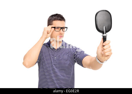 Man with glasses looking himself in a mirror isolated on white background Stock Photo