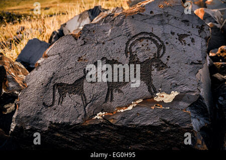 Ancient pictogram of animals on rock on Saimaluu Tash site in Kyrgyzstan Stock Photo