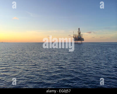 Oil rig at sunset Stock Photo