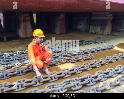 Dock worker in a shipyard talking on a walkie talkie Stock Photo