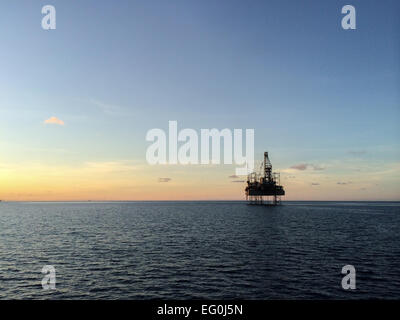 Silhouette of an offshore platform during sunset Stock Photo