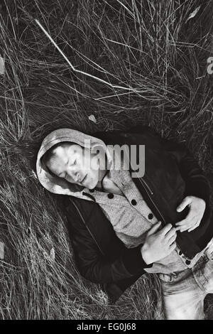 Man lying in grass sleeping Stock Photo