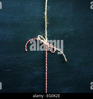 Red and white string tied in a bow with brown string Stock Photo