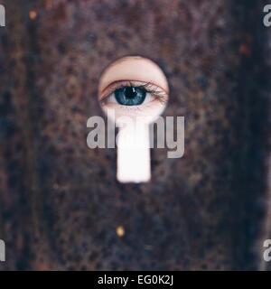 Girl (8-9)  looking through keyhole Stock Photo