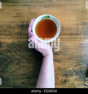 Hand with cup of tea Stock Photo