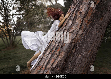 Beautiful woman hugging a tree Stock Photo