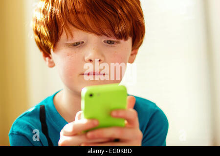 Boy playing game on a mobile phone Stock Photo