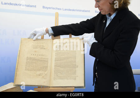 An employee of the Bavarian State Office of Criminal Investigations shows the book 'Astronomia Nova Aitiologetos' ('New Astronomy') by Johannes Kepler, at a press conference in Munich, 13 February 2015. The book was stolen from the Biblioteca dei Girolamini in Naples and seized by the Munich Department of Public Prosecution in 2012. Among the more than 500 books are original works by Galilei, Copernicus and Kepler. PHOTO: ANDREAS GEBERT/dpa Stock Photo