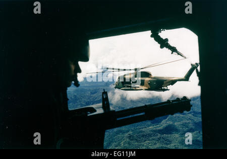 1970s -- A side view of an HH-53 helicopter from the 40th Aerospace Rescue and Recovery Squadron is visible from the gunner's position on an A-1 from the 21st Special Operations Squadron.  Ken Hackman Stock Photo