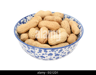 Monkey nuts in a blue and white porcelain bowl with a floral design, isolated on a white background Stock Photo