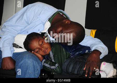 Haitian evacuees rest from exhaustion while in flight aboard the Mississippi Air National Guard C-17 Globemaster III enroute from Port-au-Prince International Airport Stock Photo