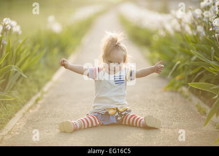 funny girl with Down syndrome sitting in the sunset sun Stock Photo