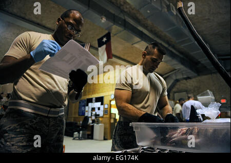 U.S. Air Force Tech. Sgt. Anthony Williams, 379 Blood Transshipment Center BTC, verifies information that Maj. Brian Dart reads to him from blood products at the BTC at an undisclosed location in Southwest Asia, Oct. 9, 2010.  The personnel at the Blood Transshipment Center ensure that the correct type and quantity of blood products were sent before it is stored or repacked for shipment to forward locations.  Staff Sgt. Eric Harris Stock Photo