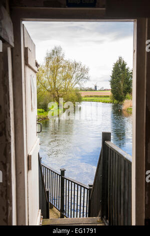 view of Pakenham windmill from inside Pakenham watermill across the millpool Suffolk Stock Photo