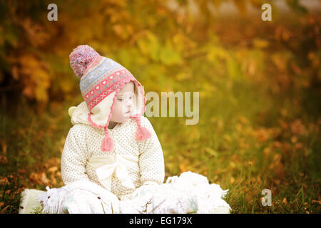 Girl with Down syndrome is resting in autumn park Stock Photo