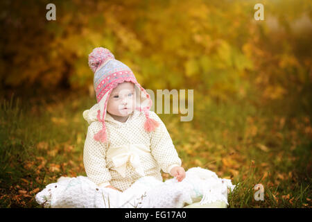 Girl with Down syndrome is resting in autumn park Stock Photo