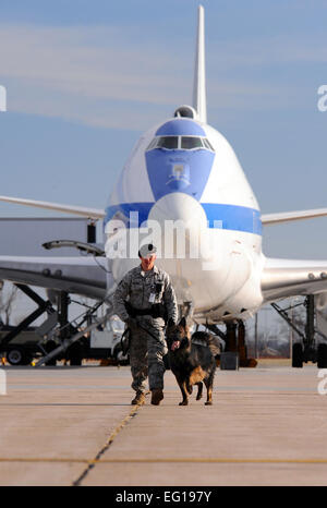 U.S. Air Force Staff Sgt. Joel Therrien, a military working dog handler with the 55th Security Forces Squadron, walks down the Bravo ramp at Offutt Air Force Base, Neb., while doing a routine sweep of the fence line with his dog Dasty, a Belgian Tervuren, Dec. 1, 2010.  Dasty is certified by trainers from Lackland Air Force Base, Texas, to sniff out explosives.  Military working dog teams have led explosive searches for such recent distinguished visitors as the Secretary of Defense, the Vice President, the First Lady and countless other base visitors and public events.  by Josh Plueger Stock Photo