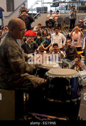 U.S. Air Force Staff Sgt. Anthony Schmaus from the U.S. Air Force Band of the Pacific performs on stage for passengers diverted from Narita International Airport inside the community center at Yokota Air Base, Japan, March 11, 2011. The jazz combo entertained passengers who stayed overnight as a result of the earthquake off the northeastern coast of Japan. Stock Photo