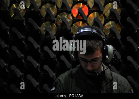 U.S. Air Force Airman John Schade, an AC-130U Spooky aerial gunner assigned to the 4th Special Operations Squadron, takes a moment to read while aboard an AC-130U aircraft during Emerald Warrior, March 4, 2011, at Hurlburt Field, Fla. Emerald Warrior is a U.S. Special Operations Command-sponsored, multiservice exercise designed to leverage lessons learned from Operations Iraqi Freedom and Enduring Freedom to provide trained and ready forces to combatant commanders.  Tech Sgt. Manuel J. MartinezReleased Stock Photo