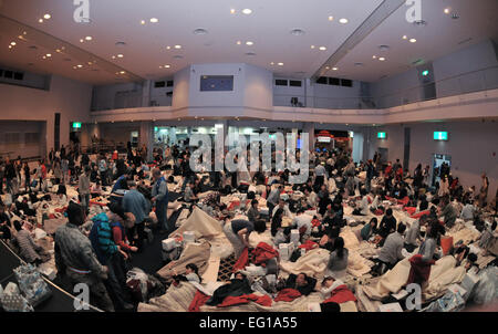 American Red Cross volunteers provide blankets and pillows to passengers of a commercial airline flight taking shelter March 11, 2011, at Yokota Air Base, Japan. The passengers arrived at the base after their flights were diverted from Narita International Airport in Tokyo, due to an 8.9-magnitude earthquake.  Airman John D. Partlow Stock Photo