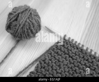 Close-up of garter stitch knitting on the needle with a ball of wool - monochrome processing Stock Photo