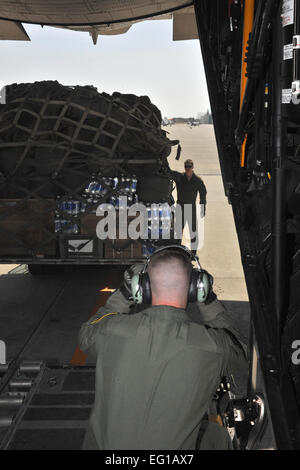 Senior Airman J.T. Mills near, and Staff Sgt. Nick Wisnoski, 17th Special Operations Squadron, Kadena Air Base, Japan load a pallet on a MC-130 at Inakuni, Marine Corp Air Station, Japan Mar. 19, 2011. The 17th SOS was at Inakuni to transport Marines in support of Operation Tomodachi. / Master Sgt. Jeromy K. Cross/released Stock Photo