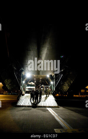 YOKOTA AIR BASE, Japan -- Airmen from the 137th Airlift Squadron, NY Air National Guard and Marines from the initial response force unload equipment from a C-5 Galaxy at Yokota Air Base April 3. The IRF is a 155-person team comprised of Marines from the Naval Support Facility, Indian Head, Md. As a smaller element of the chemical, biological and incident response force, the IRF is specifically trained in the areas of chemical, biological, radiological, nuclear and high yield explosion operations. The CBIRF will support Operation Tomodachi by providing a rapid response capability, and if reques Stock Photo