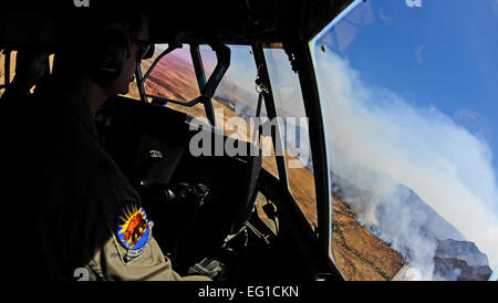 U.S. Air Force Maj. Kevin DeHart, 115th Airlift Squadron, California Air National Guard, prepares to drop a line of fire retardant while aboard a C-130J Hercules over West Texas, April 27, 2011.  The C-130 is equipped with the Modular Airborne Firefighting System which is capable of dispensing 3,000 gallons of water or fire retardant in under 5 seconds.  The wildfires have spread across various parts of Texas and have burned more than 1,000 square miles of land.   by Staff Sgt. Eric Harris Stock Photo