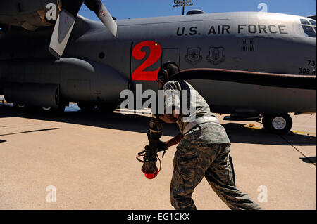 U.S. Air Force Airman 1st Class Reuben Chisholm, 7th Logistics Readiness Squadron, drags a fuel hose in order to refuel a C-130H Hercules from the 302nd Airlift Wing, Colorado Air Force Reserve, at Dyess Air Force Base, Texas, April 28, 2011.  The C-130 is equipped with the Modular Airborne Firefighting System MAFFS housed aboard a C-130 Hercules which is capable of dispensing 3,000 gallons of water or fire retardant in under 5 seconds. The 7th Bomb Wing has been supporting the 302nd AW and the 146th AW, California Air National Guard, with flight line operations while at Dyess AFB.  Staff Sgt. Stock Photo