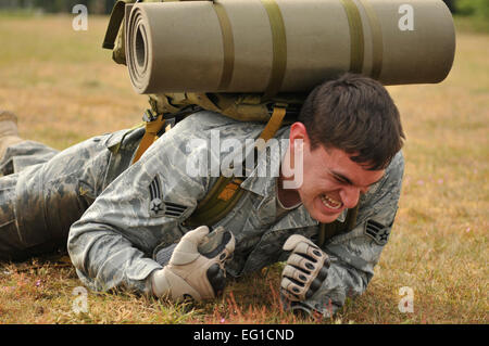 United States Air Force Senior Airman Ben Forbus, 48th Security Forces Squadron patrolman, high crawls with a 35-pound rucksack during the 5K Combat Ruck March Challenge on May 17, 2011. This is one of several events that will be held during National Police Week at RAF Lakenheath to honor police officers. The challenge required the teams to race between four checkpoints: 25 push-ups, high crawl, memory game and fireman carry. Out of the seven competing teams, Airman Forbus’ team finished first with a time of 36 minutes and 25 seconds.  Senior Airman Tiffany M. Deuel Stock Photo