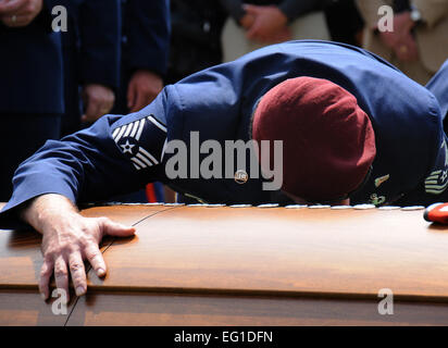 The casket of Staff Sgt. Andrew Harvell is embraced by one of his teammates during Harvell's funeral at Los Angeles National Cemetery on Sept. 10, 2011.  The casket is adorned with more than 100 combat controller and pararescue flashes hammered in by Harvell's teammates in one final tribute.  Harvell was a combat controller who died Aug. 6 when the CH-47 helicopter he was traveling in crashed in the Wardak province of Afghanistan.  Harvell was one of 30 Americans who died.   Joe Juarez Stock Photo