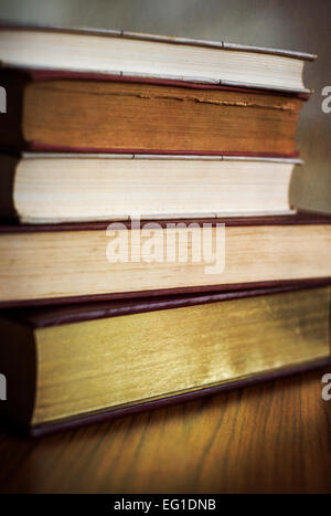A pile of old books on a wooden table Stock Photo