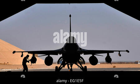 A weapons loader from the 125th Expeditionary Fighter Squadron performs a post flight check on an F-16 Fighting Falcon after its arrival in Iraq Oct. 1, 2011. The squadron deployed in support of Operation New Dawn and will provide close air support for more than 40,000 troops leaving Iraq by the end of the year. The 125th EFS is comprised of F-16s, pilots, maintenance specialists and support personnel from the Oklahoma Air National GuardÕs 138th Fighter Wing in Tulsa, Okla. The squadron also includes members from the Ohio Air National GuardÕs 180th Fighter Wing in Toledo, Ohio, and the Arizona Stock Photo