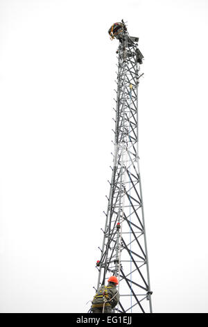 U.S. Air Force Chief Master Sgt. Russell Youngs and Tech. Sgt. Michael Griepsma climb to the top of an 85-foot communications tower at Adirondack Range, Fort Drum, N.Y., Nov. 22, 2011. The towers hold cameras used to view targets down range. Youngs is the 174th Fighter Wing command chief.  Tech. Sgt. Ricky Best Stock Photo