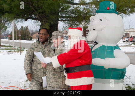 U.S. Air Force Chaplain Maj. Obadiah Smith left, Col. William T. Cahoon and Santa Claus sing “Oh Christmas Tree” outside the Airman and family readiness center Dec. 3, 2011, at Grissom Air Reserve Base, Ind. Cahoon is the 434th Air Refueling Wing commander and Smith is the 434th ARW chaplain.  Senior Airman Andrew McLaughlin Stock Photo