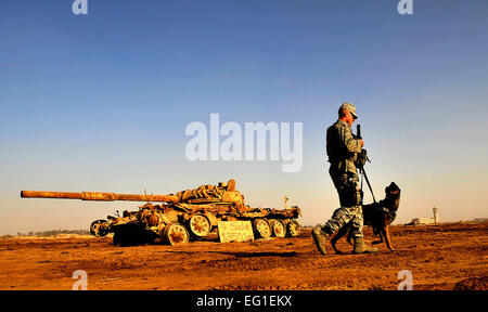 U.S. Air Force Senior Airman Stephen Hanks, a military working dog handler assigned to the 447th Expeditionary Squadron ESFS, and Geri, a patrol and explosive detector dog with the 447th ESFS, patrol the perimeter of Sather Air Base in Baghdad, Iraq, Dec. 11, 2011. For the past six months, Geri and Hanks have been supporting Operation New Dawn by providing explosive and psychological deterrence.  Master Sgt. Cecilio Ricardo Stock Photo