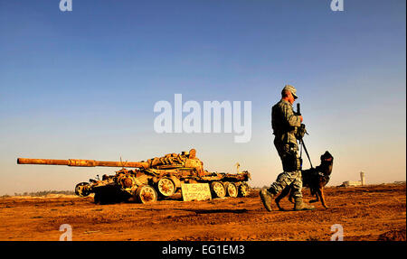 U.S. Air Force Senior Airman Stephen Hanks and Geri, a patrol and explosive detector dog, both with the 447th Expeditionary Security Forces Squadron, patrol the perimeter of Sather Air Base, Dec. 11, 2011, in Baghdad, Iraq.  Master Sgt. Cecilio Ricardo Stock Photo