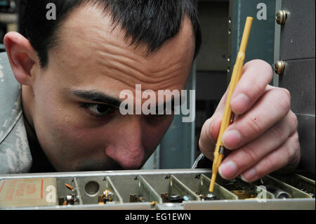 U.S. Air Force Airman 1st Class Alan Williams adjusts power levels on a ground-to-air transmitter during a preventative maintenance inspection Jan. 26, 2012, at Eielson Air Force Base, Alaska. The inspection ensures the device uses proper power levels to send and receive transmissions. Williams is an airfield systems technician assigned to the 354th Communications Squadron.  Staff Sgt. Christopher Boitz Stock Photo